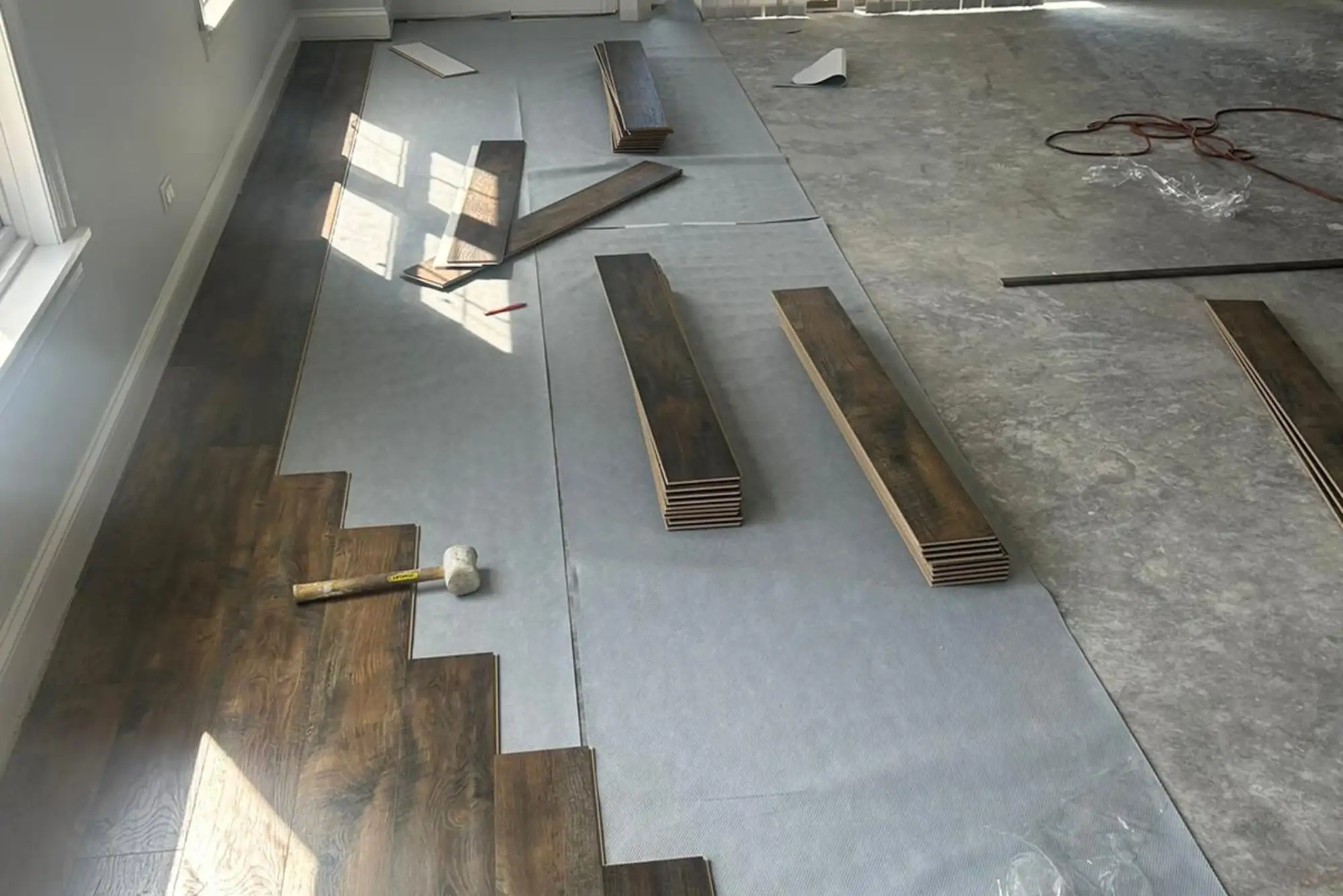Skilled professionals installing laminate flooring, ensuring a seamless and durable finish.