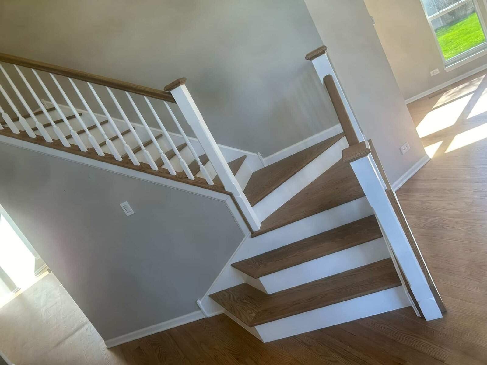 Side view of newly installed hardwood stairs with white risers in a Barrington IL home